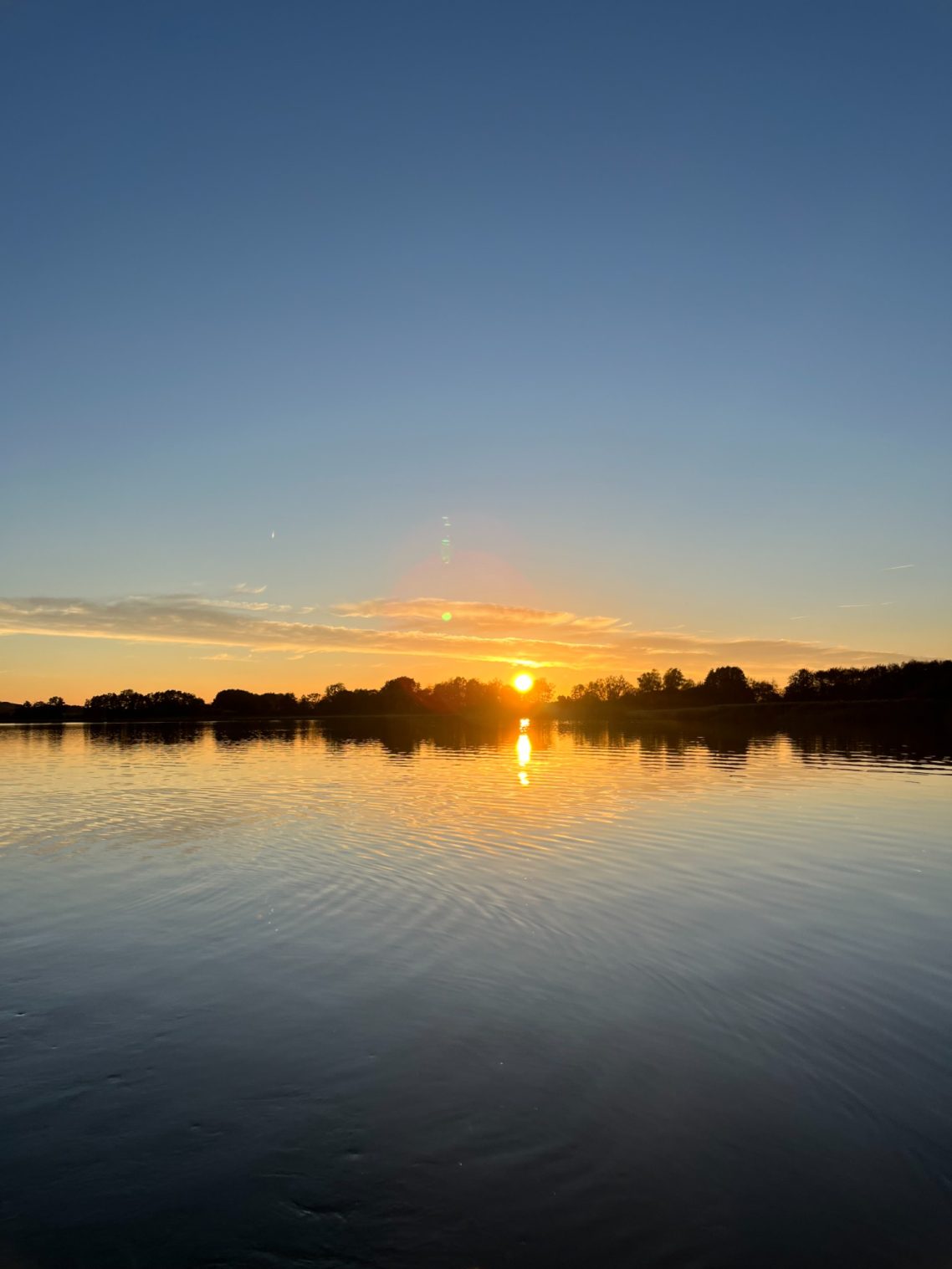 Sonnenuntergang am Trenntsee. Immer wieder zauberhaft schön. Sonnenuntergang über einem ruhigen See mit reflektierendem Wasser.