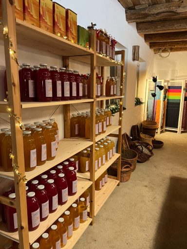 Frisch gepresst und fertig zum mitnehmen. Regale mit verschiedenen Getränkeflaschen auf Holzregalen in einem Geschäft.